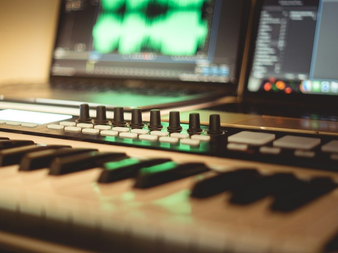 Nahaufnahme eines Synthesizers mit Klaviertasten und Studio-Bildschirmen