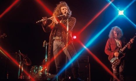 Progressive-Rock-Band mit Flötist und Gitarrist auf einer farbig beleuchteten Bühne